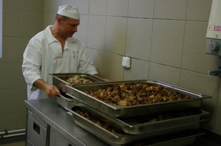 Šéf směny kuchařů kontroluje upečené maso k večeři