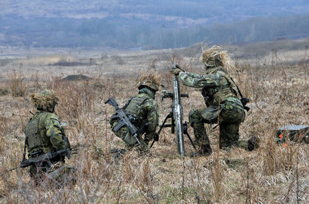 Nabíječ vkládá minu do hlavně 82 mm minometu