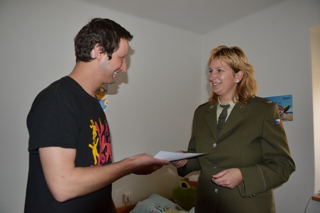 Rotmistryně Jitka Novotná předává desátníku Stanislavu Vajdovi šek s finanční pomocí Vojenského fondu solidarity