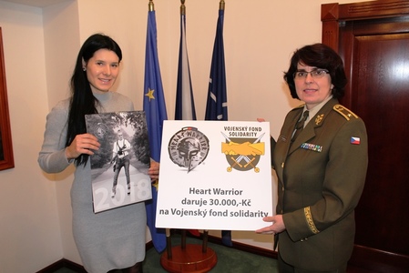 Symbolické předání šeku, Tereza Knihová (vlevo) drží v ruce kalendář, výtěžek z jeho prodeje předala Vojenskému fondu solidarity. 