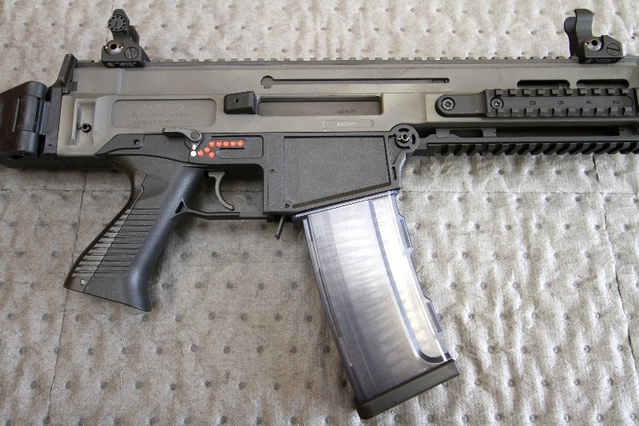 Detail na pouzdro zbraně, dioptrická mířidla, sestavu pažbičky, páčku přeřaďovače režimu střelby, zásobníkovou šachtu, zásobník