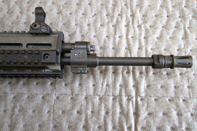 Detail na sestavu hlavně s tlumičem plamene, plynovým násadcem s plynovou trubicí a výstupkem pro upnutí útočného nože