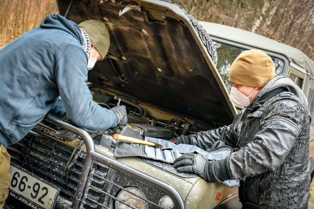 Porouchaný automobil zatarasil cestu a kdosi se jej snaží opravit