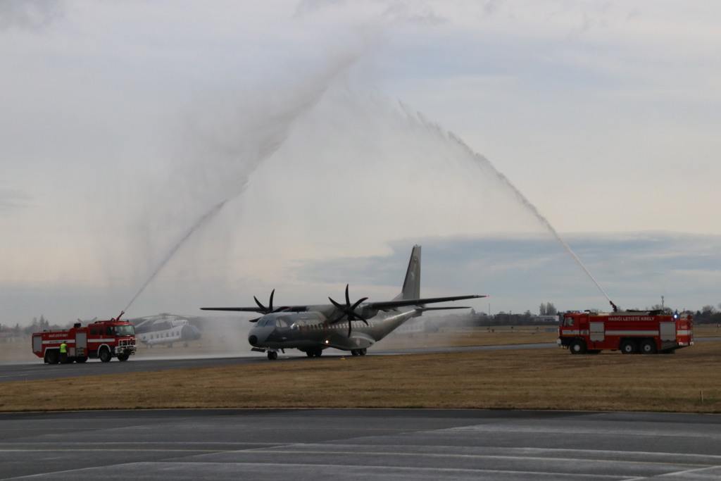 Letoun CASA C-295M projíždí slavobránou, kterou mu připravila vojenská hasičská jednotka v pražských Kbelích