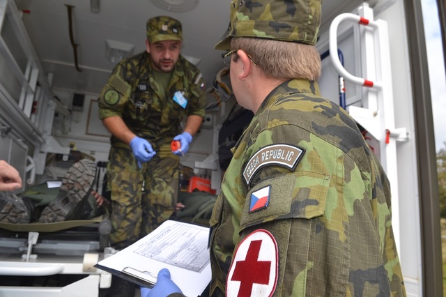 Čeští zdravotníci nakládají raněné do sanitky a přepravují je k následné péči