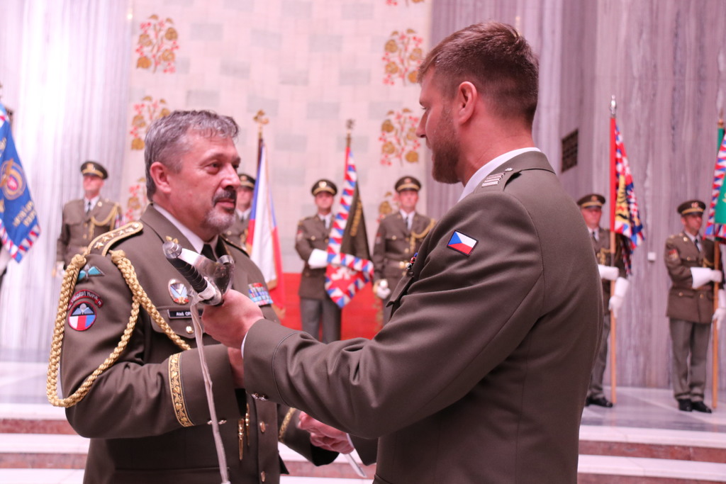 Z rukou armádního generála Aleše Opaty rotmistrovskou šavli přebírá nový vrchní praporčík nadpraporčík Peter Smik