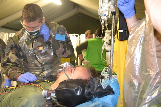 Ošetření českého raněného vojáka v polní nemocnici provádí člen francouzského zdravotního týmu