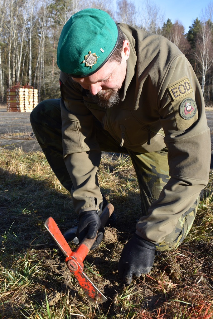 Pyrotechnik EOD prověřuje místo a pomalu odkrývá nález