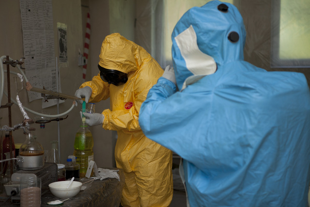 V nelegální chemické laboratoři odebírají chemici vzorky neznámé látky