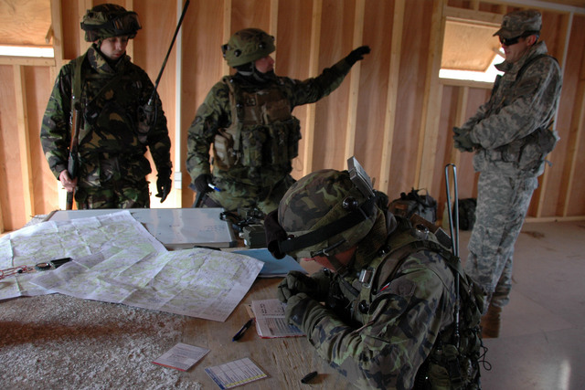 Jak postupovat? Češi a Afghánci společně plánují postup. V pozadí vpravo americký instruktor, který reakce jednotky sleduje