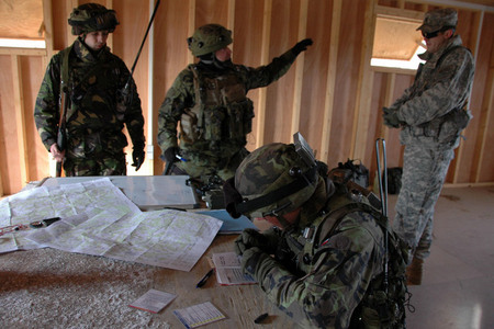 Jak postupovat? Češi a Afghánci společně plánují postup. V pozadí vpravo americký instruktor, který reakce jednotky sleduje