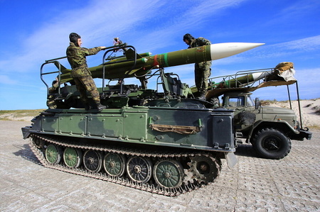 Po vyhlášení signálu G-120 nabíjejí vojáci rakety na odpalovací zařízení. 