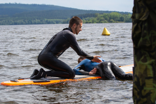 Členové Vodní záchranné služby během instruktáře, jak použít paddleboard při dopomoci indisponovanému plavci.