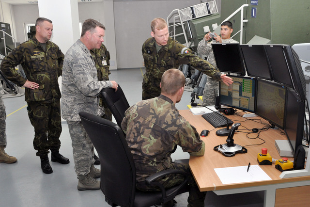 Generálové zleva Zižka a Nichols sledují předvedení simulátoru bojových vozidel