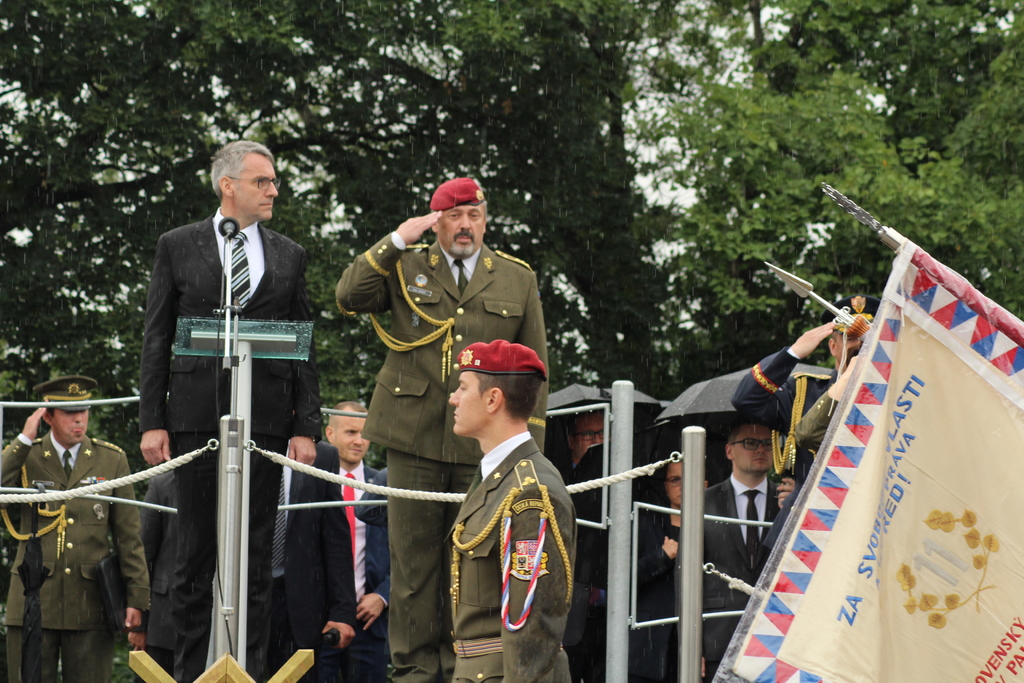 Ministr Metnar a generál Opata přihlížejí přinesení historických bojových praporů