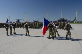 Čestná stráž nese státní vlajku a bojovou zástavu útvaru