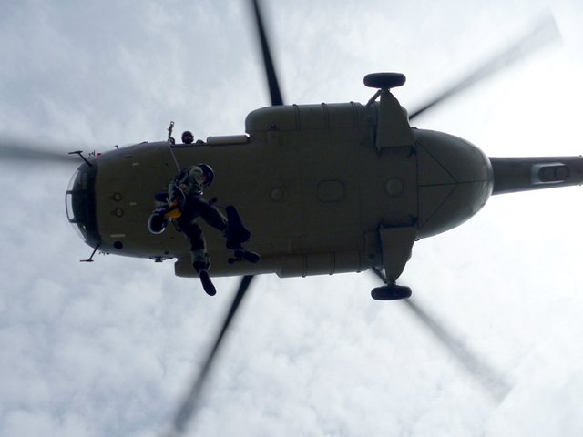 Záchranář slaňuje z vrtulníku Mi-17 na plochu letiště Rakovník 