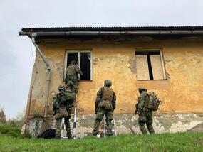 Pátrací skupina s EOD operátory vstupuje do zájmové budovy