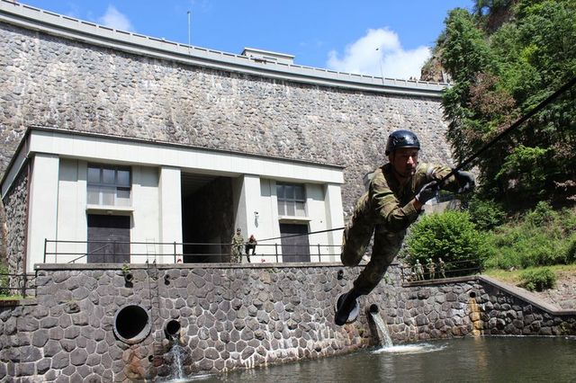 praporčík Vratislav Louda z velitelství brigády překonává  vodní překážku za pomocí fixního lana