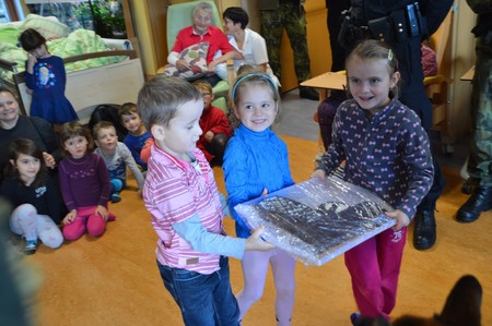 Děti z místní školy předaly Vojenským policistům na znamení vděku dort ve tvaru pistole