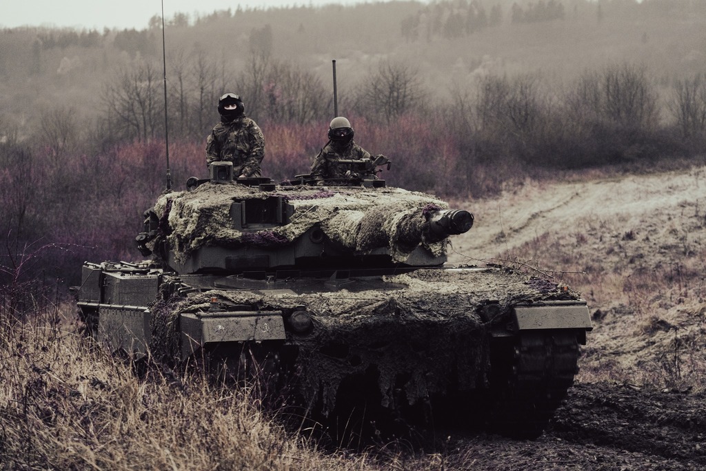 Tank Leopard 2A4 během cvičení Tasmanian Lizard II ve vojenském újezdu Hradiště. Maskování tanku a posádky ilustruje připravenost na bojové situace v náročném terénu a proměnlivých