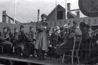 Vojenské hudby vyhrávaly při celostátních spartakiádách, tak i dělníkům v továrnách (1955).